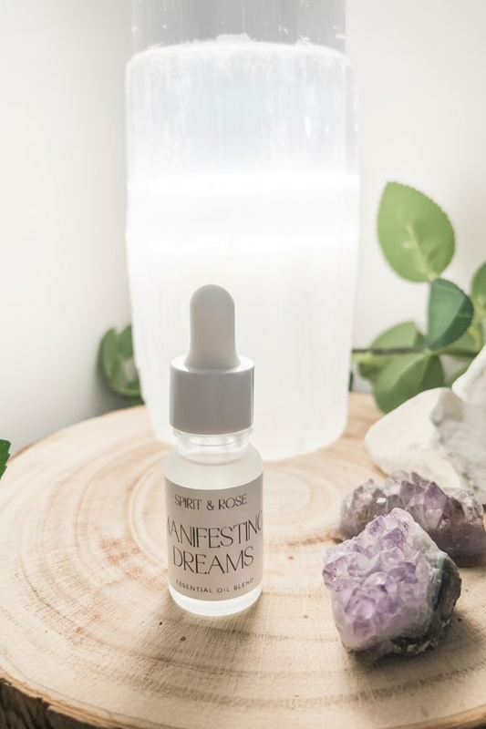 Bottle of 'Manifesting Dreams' with crystals and a crystal lamp on a wooden surface